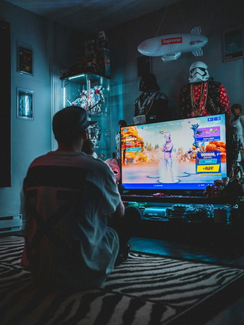 man in red shirt watching tv